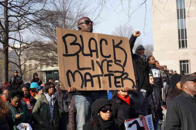 Un uomo che protesta per la morte di Michael Brown, Eric Garner e Tamir Rice mostra un Black Lives Matter a Washington DC.