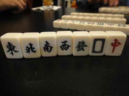 Le tessere dei venti e dei draghi in un set di Mahjong in piedi su un tavolo.