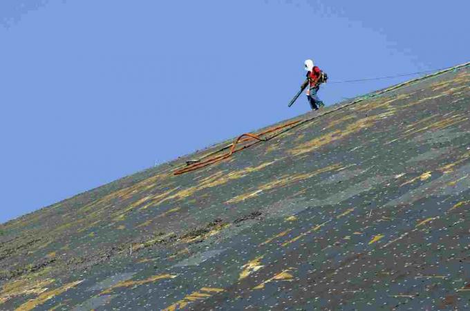 lavoratore che cammina sul tetto a cupola danneggiato dall'uragano Katrina che ha colpito la regione della costa del Golfo il 29 agosto.