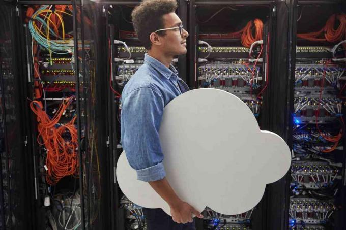 Tecnico IT maschio che trasporta cloud nella sala server, cloud computing