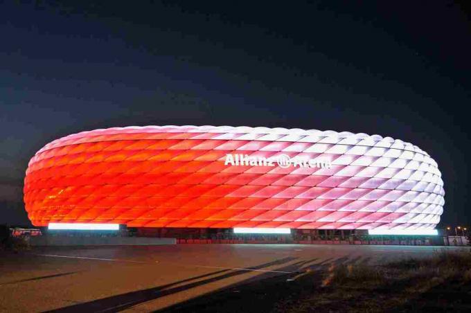 bianco di giorno, l'esterno scolpito dell'Allianz Arena si illumina di rosso di notte