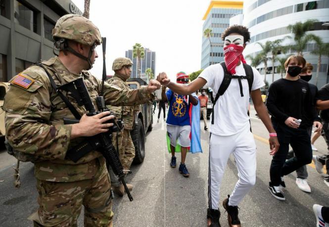 Un pugno di dimostrante urta un membro della Guardia Nazionale durante una marcia in risposta alla morte di George Floyd il 2 giugno 2020 a Los Angeles, California.