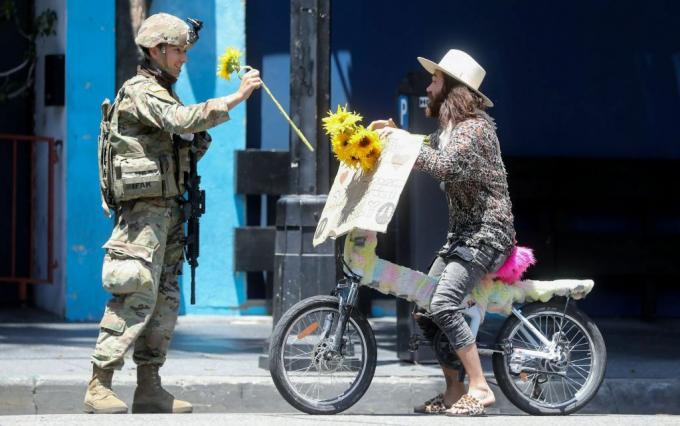 Un soldato della Guardia Nazionale riceve un fiore da un manifestante durante una manifestazione pacifica per la morte di George Floyd a Hollywood il 3 giugno 2020.