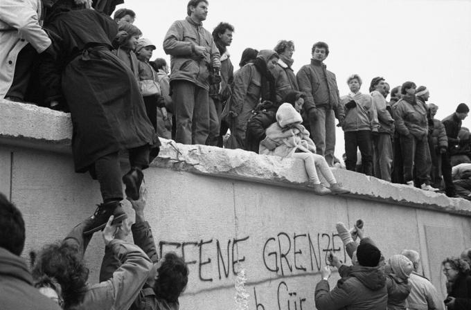 I berlinesi orientali in cima al muro di Berlino, 1989
