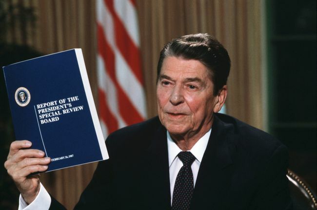 Il presidente Ronald Reagan con in mano una copia del rapporto della Tower Commission sullo scandalo Iran-Contra