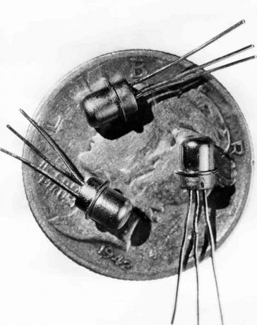 Immagine datata 1956 di tre transistor M-1 in miniatura visti sulla faccia di una monetina