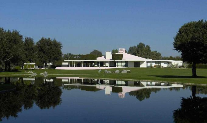 La casa moderna della metà del secolo nella California meridionale si riflette in uno stagno all'interno della proprietà.