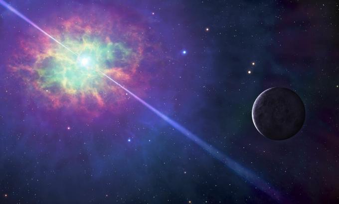 Immagine dello spazio, con una nuvola colorata che circonda una stella che proietta fasci di luce in due direzioni, con un pianeta illuminato nelle vicinanze.