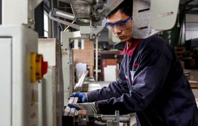 Un dipendente che lavora su prodotti in alluminio in una fabbrica di Zouping, nella provincia cinese dello Shandong