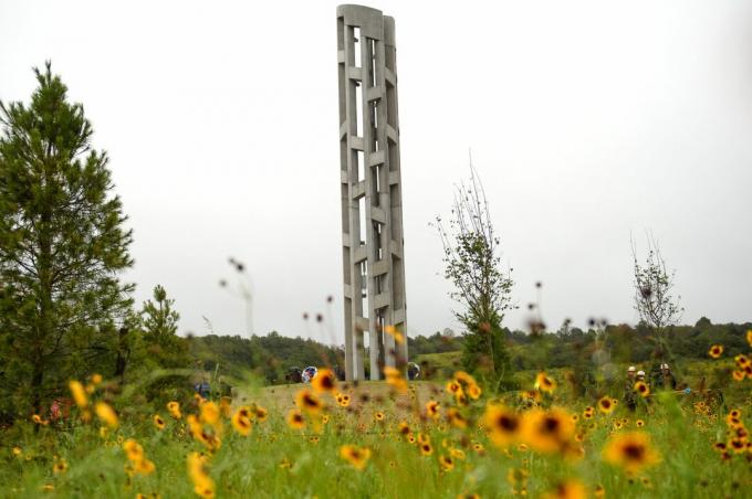 campanile di pietra alto e sottile in un campo di fiori