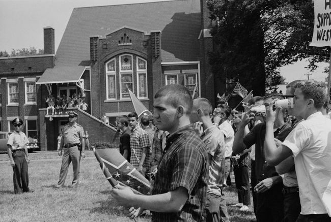 Una folla di studenti della Woodlawn High School di Birmingham, Alabama, battendo la bandiera confederata in opposizione all'inizio della campagna di Birmingham, maggio 1963