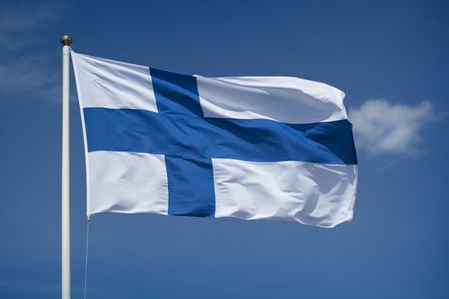 Bandiera finlandese issata con uno sfondo di cielo blu