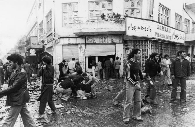 4 novembre 1978 La gente si riunisce intorno a un ferito mentre altri saccheggiano un negozio dopo una rivolta a Teheran