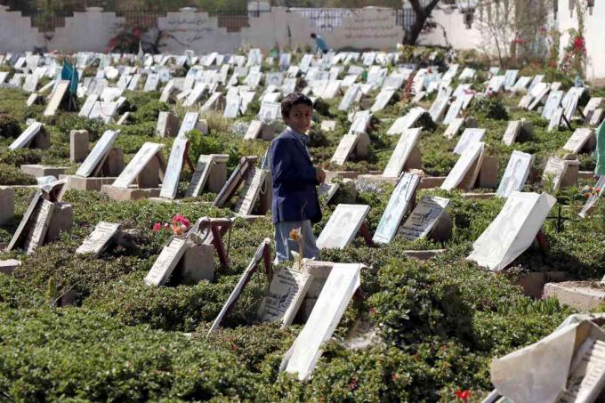 Un bambino cammina tra le tombe di persone che sono state uccise durante la guerra in corso in un cimitero di Sana'a, nello Yemen.
