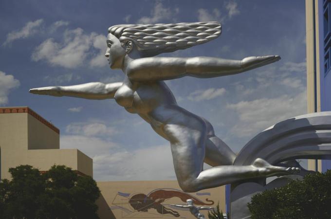 scultura d'argento di donna nuda che sembra correre, con i capelli che scorrono dietro, un braccio in avanti e un braccio dietro
