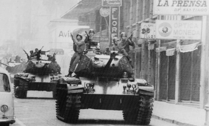 I soldati cavalcano sui carri armati per le strade di Santiago del Cile, mentre il generale dell'esercito Augusto Pinochet ha prestato giuramento come presidente.