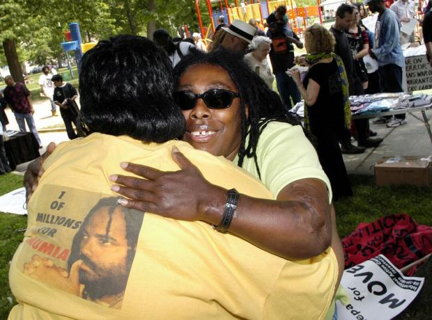 Ramona Africa (R), l'unica sopravvissuta alla tragedia MOVE del 1985, abbraccia Denise Garner (L) durante una marcia commemorativa nel 2005