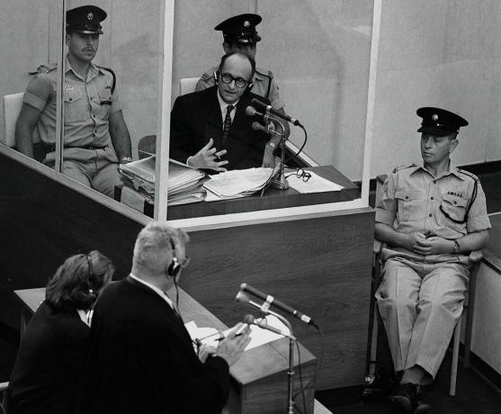 Il criminale di guerra nazista Adolph Eichmann si trova in una cabina di vetro protettiva affiancata dalla polizia israeliana durante il suo processo il 22 giugno 1961 a Gerusalemme.